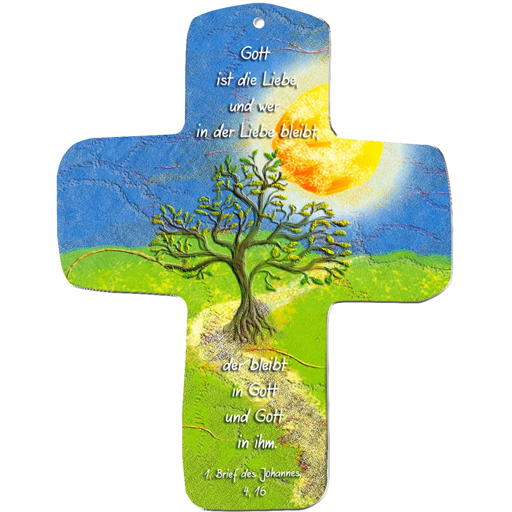 Ein farbenfrohes metALUm Wandkreuz in Kreuzform zeigt einen grünen Baum auf einem gewundenen Pfad unter Sonne und Himmel, mit dem deutschen Text: Gott ist die Liebe... 1. Brief des Johannes 4,16 - ein ideales Geschenk für Kinder als Symbol des Brotes des Lebens.